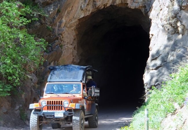 Colorado Jeep Tour-jeep with guests driving out of tunnel on a sunny day
