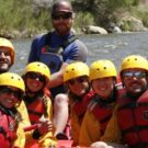 whitewater rafting tour group and guide posing for photo